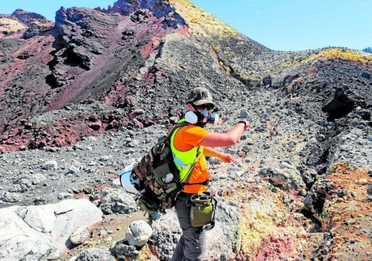Un técnico del Igme señala una grieta en el cráter del volcán Tajogaite, en La Palma.