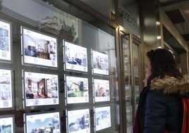 Dos jóvenes consultan las ofertas de una inmobiliaria.