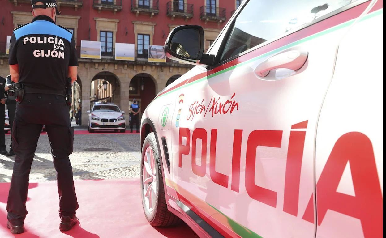 Un agente de la Policía Local junto a su vehículo.