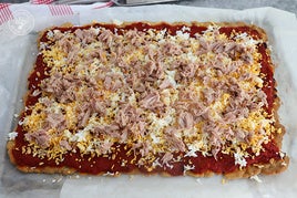 Coca de tomate, huevo y atún con pimiento y piñones