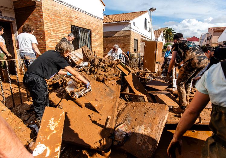 Los vecinos se afanan en Utiel para retirar los enseres arrastrados por las aguas.